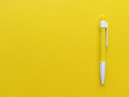 caneta amarela e branca em fundo amarelo plano minimalista plano com espaço de cópia foto. foto