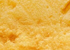 a superfície, a fibras do a esponja. dourado amarelo limpeza esponja, poroso superfície, ar bolhas. foto