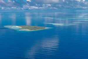 ilhas tropicais e atóis nas maldivas de vista aérea. famoso destino de viagem e férias de luxo ou conceito de férias de verão. paisagem aérea do mar azul e resorts, hotéis. natureza bela foto