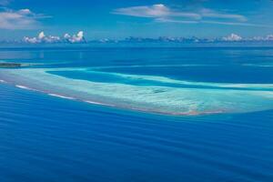 ilhas tropicais e atóis nas maldivas de vista aérea. famoso destino de viagem e férias de luxo ou conceito de férias de verão. paisagem aérea do mar azul e resorts, hotéis. natureza bela foto