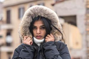 jovem bonita congelando em um casaco de inverno em pé na rua retrato de inverno foto