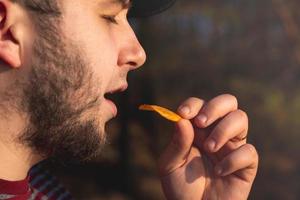 homem barbudo na floresta comendo batatas fritas foto