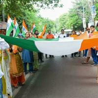 Délhi, Índia -15 pode 2023 - ampla grupo do pessoas durante grande tiranga yatra organizado Como parte do a azadi ka amrit mahotsav para comemoro a 76 aniversário do da Índia independência, indiano bandeira marcha foto