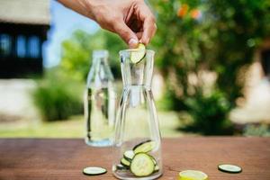 colocando pepino na garrafa de vidro foto