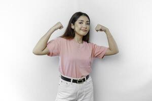 animado ásia mulher vestindo uma Rosa camiseta mostrando Forte gesto de elevação dela braços e músculos sorridente orgulhosamente foto