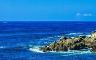 surfista ondas turquesa azul água pedras falésias pedregulhos porto escondido. foto