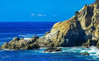surfista ondas turquesa azul água pedras falésias pedregulhos porto escondido. foto