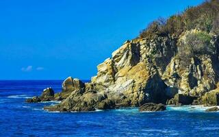 surfista ondas turquesa azul água pedras falésias pedregulhos porto escondido. foto