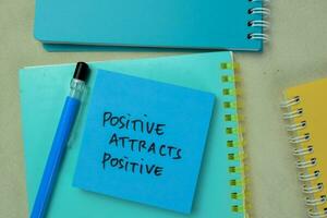 conceito do positivo atrai positivo escrever em pegajoso notas isolado em de madeira mesa. foto