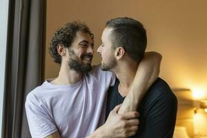 retrato do despreocupado gay casal dentro de casa. feliz gay casal gastos Tempo juntos foto