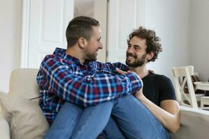 amoroso mesmo sexo masculino gay casal deitado em sofá às casa e relaxante, abraço juntos foto