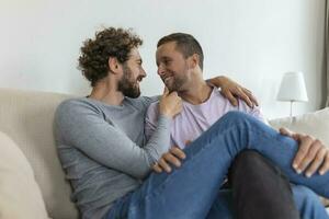 retrato do despreocupado gay casal dentro de casa. feliz gay casal gastos Tempo juntos segurando mãos foto