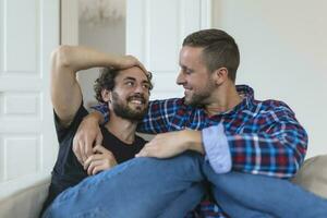 amoroso mesmo sexo masculino gay casal deitado em sofá às casa e relaxante, abraço juntos foto