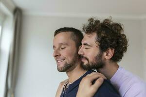 retrato do despreocupado gay casal dentro de casa. feliz gay casal gastos Tempo juntos foto