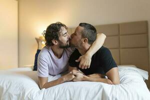 dois jovem homem lgbtq gay casal namoro dentro amor abraçando desfrutando íntimo concurso sensual momento juntos se beijando com olhos fechadas foto