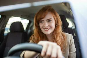 lindo jovem mulher dirigindo dela Novo carro às pôr do sol. mulher dentro carro. fechar acima retrato do agradável olhando fêmea com feliz positivo expressão, mulher dentro casual vestem dirigindo uma carro foto