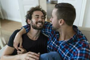 amoroso mesmo sexo masculino gay casal deitado em sofá às casa e relaxante, abraço juntos foto