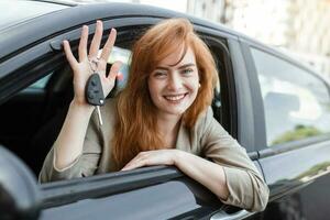 jovem mulher sorridente mostrando dela Novo carro chaves, chaves para dela aluguel carro. foto