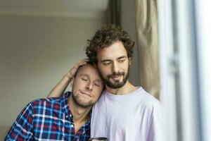 alegre jovem gay casal sentado junto. dois afetuoso masculino amantes sorridente alegremente enquanto abraçando cada outro. jovem gay cupê ser romântico. foto