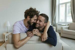 feliz gay casal deitado baixa em a cama às lar, abraçando e flertando. lgbt gay casal amor momentos felicidade conceito foto