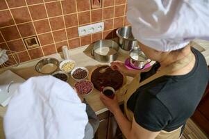 topo Visão fêmea chefe de cozinha pasteleiro, amoroso mãe, dona de casa preparando uma delicioso caseiro sobremesa dentro a casa cozinha foto