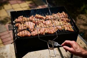 topo Visão marinado carne de porco filé mignon grelhar em a grato sobre carvão em churrasco grade ao ar livre. Comida preparativos foto