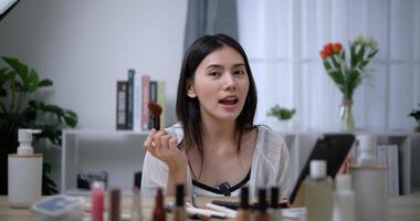 lindo jovem ásia mulher blogueiro mostra quão para faço acima e usar cosméticos foto