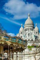 carrossel e a histórico sacre Coeur basílica construído em a dezoito século às a Montmartre Colina dentro Paris França foto