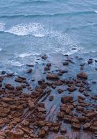 penhasco e rochas e mares na costa foto