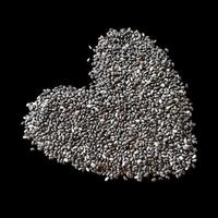 forma de coração de sementes de chia isoladas em fundo preto foto