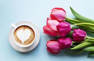 xícara de café com latte art e tulipas