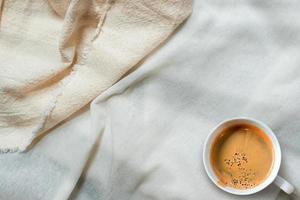 vista superior de uma xícara de café em uma toalha de mesa branca foto