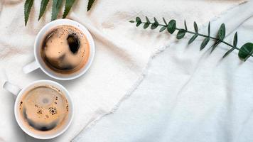 vista superior de uma xícara de café em uma toalha de mesa branca foto