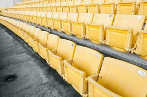 esvaziar amarelo assentos às estádio, linhas do assento em uma futebol estádio, selecione foco foto