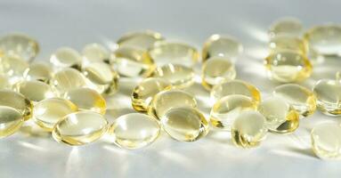 Vitamina d amarelo suplemento gel cápsulas, peixe óleo ómega 3 em branco fundo, macro tiro foto