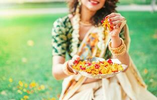 sul indiano mulher segurando flor pétalas para comemoro a tradicional festival foto