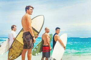 grupo do surfistas em uma de praia foto