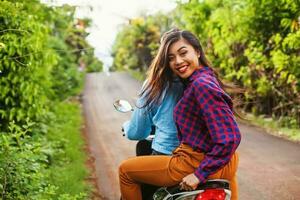 feliz indonésio mulher equitação Como uma passageiro do moto Táxi foto