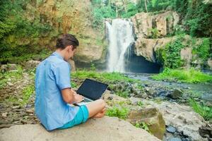 bem sucedido homem com computador portátil ao ar livre foto