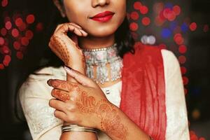 sem rosto retrato do indiano mulher com lindo mehndi em dela mãos, vestindo tradicional étnico terno e dupatta foto