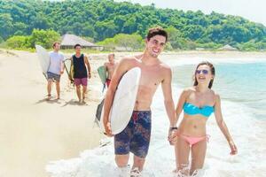 grupo do surfistas em uma de praia foto