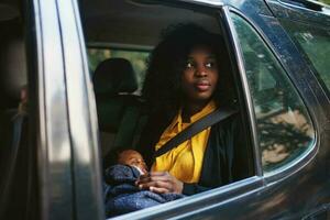 afro mulher com bebê em a carro foto