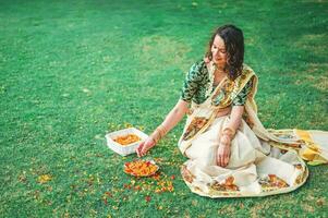 indiano mulher dentro a parque com flor pétalas foto