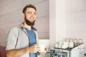 bonito barista com barba fazer café dentro uma cafeteria foto