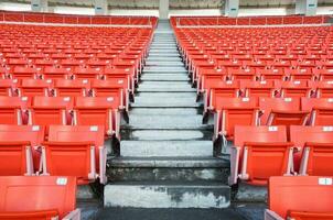 esvaziar laranja assentos às estádio, linhas passarela do assento em uma futebol estádio foto