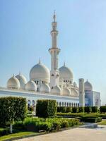 lindo branco torre do a mesquita contra a céu dentro a luz solar. a famoso sheikh zayed grande mesquita. foto