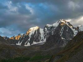 montanha alcance às nascer do sol.incrível cenário com iluminado pelo sol neve montanhas dentro nublado céu às nascer do sol. Sombrio cênico panorama com ampla geleira dentro nascer do sol cores. foto