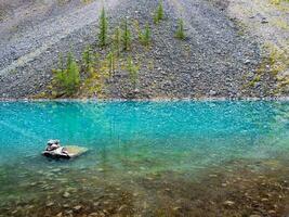 limpar \ limpo montanha lago. azul glacial lago com Claro água superfície dentro luz solar. lindo cênico panorama com turquesa montanha lago com transparente água e pedregoso fundo. foto