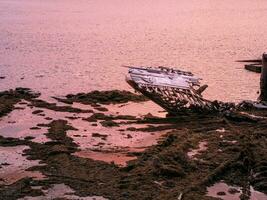 a velho oxidado pescaria barco abandonado de uma tempestade em a costa. cemitério do navios. foto