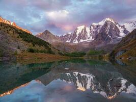 pôr do sol dentro magenta tons. glacial lago Alto dentro a montanhas. atmosférico roxa panorama com uma lago dentro uma grande altitude Nevado montanha vale. foto